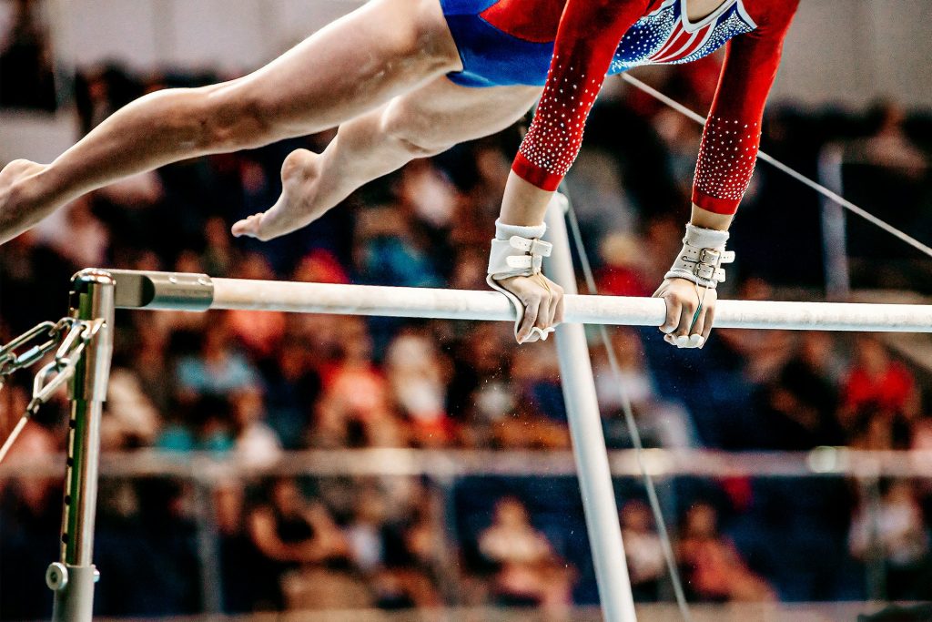 close-up body part female gymnast exercise on uneven bars in artistic gymnastics